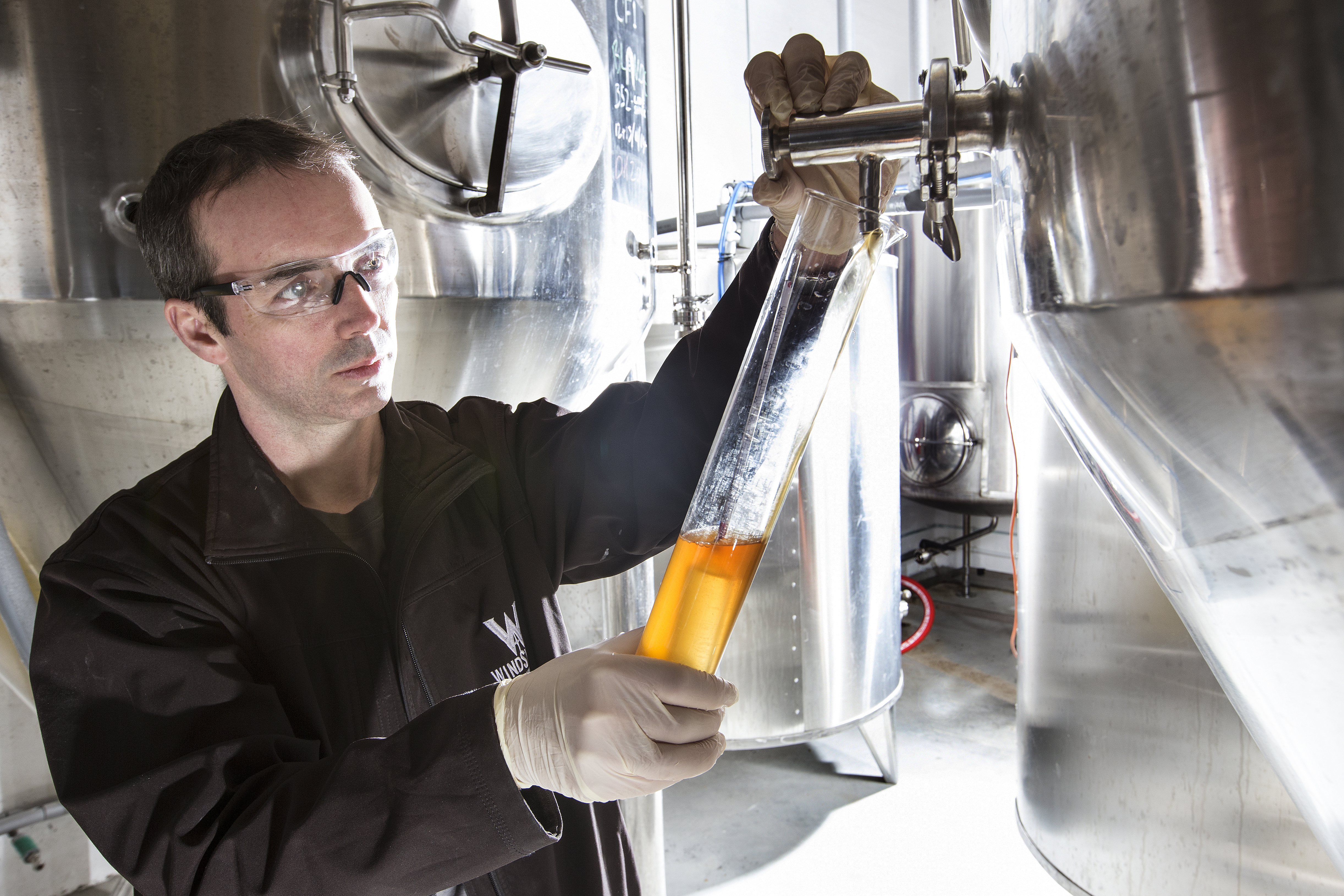 Distiller drawing beer from still at Windswept brewery 