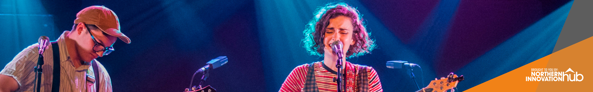 Woman singing at XpoNorth backlit by blue light