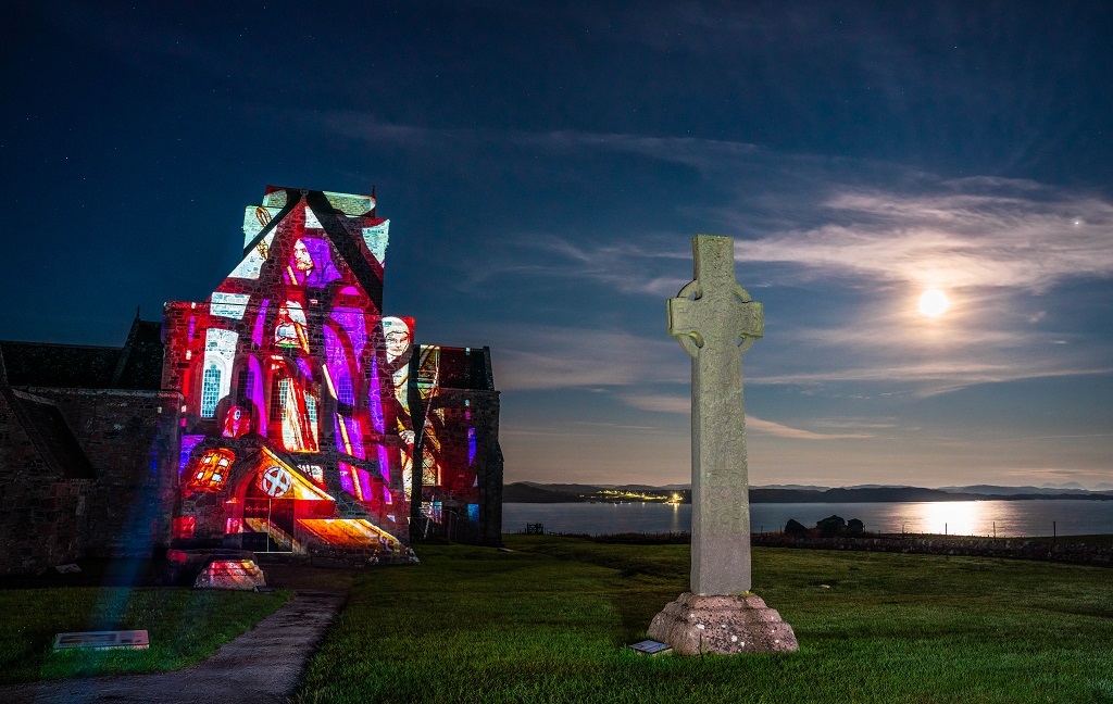 A colourful projection illuminating the wall of an abbey